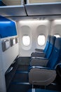 The interior of the aircraft. Empty airplane cabin. Rows of passenger seats with screens in the head restraints