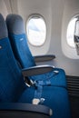 The interior of the aircraft. Empty airplane cabin. Rows of passenger seats with screens in the head restraints