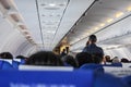 Interior of an airplane filled with passengers; air hostesses engaged in conversation,  before the safety demonstration Royalty Free Stock Photo