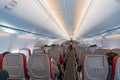 Interior of airplane with passengers on seats and stewardess in