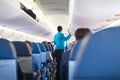 Interior of airplane with passengers on seats.