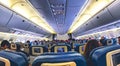 The interior of an airplane with passengers sitting in seats.