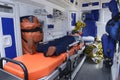 Interior of an ambulance car: man lying on stretcher, medical equipment, bags, first aid kit Royalty Free Stock Photo