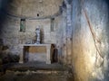 The interior of an ancient, small and forgotten church. Lunigiana, Italy. With statue and crucifix.