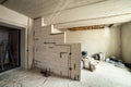 Interior of an apartment room with bare walls and ceiling under construction