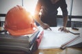 Interior Architect with blueprint for architectural plan, engineer sketching a construction project concept in engineer office