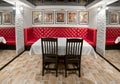 Interior banquet room with a large red sofa, table, chairs, mirrors and paintings