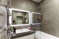 Russia, Moscow, 08.03.2019, interior of the bathroom, in gray tones, with a large illuminated mirror, shower and bathtub