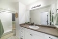 Interior of a bathroom with white marble top sink with white cabinet and mirror Royalty Free Stock Photo