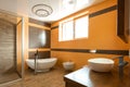 interior of bathroom in orange and white colors with bathtube sink Royalty Free Stock Photo