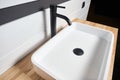 Interior of bathroom with square ceramic wash basin and black faucet. Bathroom interior sink with wooden Solid ash glued Royalty Free Stock Photo