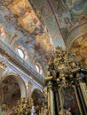 The interior of a beautiful historic Catholic church, with beautiful decorations on the walls, golden details