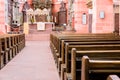 Interior of a beautiful old catholic church from below with marble floor, wooden pews, and light streaming onto altar Royalty Free Stock Photo