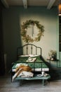 Interior of a bedroom with a large bed in green, decorated for Christmas and New year