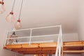 Interior of bedroom with wooden stairs and bed on second floor with bedside table, pendant light hanging on ceiling Royalty Free Stock Photo