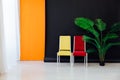 Interior of a black and orange room with colored chairs, armchairs