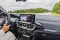 Interior of BMW iX3 M Sport electric car driving along highway with female driver.