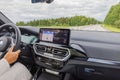 Interior of BMW iX3 M Sport electric car driving along highway with female driver. Royalty Free Stock Photo