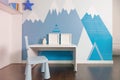The interior of the boy's room in blue colors, mountains on the walls. Realistic.