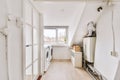 Interior of modern mansard laundry room with white walls