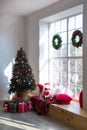 Interior of bright modern living room with big panoramic window decorated with Christmas tree and gifts Royalty Free Stock Photo