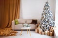 Interior of bright modern living room with comfortable sofa decorated with Christmas tree and gifts