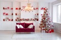 Interior of bright modern living room with fireplace, chandelier and comfortable sofa decorated with Christmas tree and Royalty Free Stock Photo