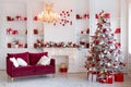 Interior of bright modern living room with fireplace, chandelier and comfortable sofa decorated with Christmas tree and Royalty Free Stock Photo