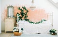 Interior of bright white bedroom with decorative flowers on a wall Royalty Free Stock Photo