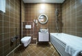 Interior of brown bathroom with bathtub, sink and toilet