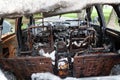 The interior of burnt-out car. Melted plastic of dashboard and rusted remains of seats. Selective focus Royalty Free Stock Photo