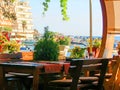 Interior cafe on the coast, an empty wooden table and chairs decorated with plants. The veranda of the seaside cafe