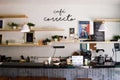 interior of cafeteria with wooden bar counter, shelves and board with drawn coffee cup