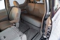 The interior of the car in the back of a minivan with a wide open automatic door and a view of the front and rear seats in beige Royalty Free Stock Photo