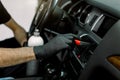 Interior Car Care, Car detailing concept. Cropped image of hands of young male worker in black protective gloves