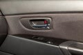 The interior of the car with a view of the passenger door with buttons, armrest and light gray leather after detailing and dry