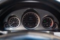 The interior of the car with a view of the steering wheel, dashboard, speedometer and tachometer with light gray trim