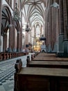 Interior of the Catholic Church. Large wooden benches for prayer. Royalty Free Stock Photo