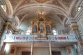 Interior of a catholic church in South Tyrol with numerous ornate columns, a golden pipe organ Royalty Free Stock Photo