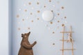 The interior of the children`s room is decorated in blue and beige colors. The bear holds a small balloon in his hands Royalty Free Stock Photo