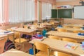 Interior class in elementary school, students desks and desk teachers board in the background