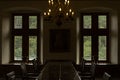Interior classical room in medieval castle. Dining room with table, chairs and windows. Royalty Free Stock Photo