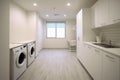 Interior clean white laundry room with front load washer and dryer units. Royalty Free Stock Photo