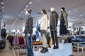 Interior of clothing store which mannequins in form of man and woman are stands on different levels.