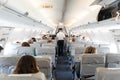 Interior of commercial airplane with passengers on their seats during flight.