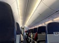 Interior of commercial airplane with unrecognizable passengers on their seats during flight shot from the rear of airplane. Royalty Free Stock Photo