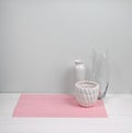 Interior composition of a home, pot, glass and ceramic vase on pink napkin, white wood background. Modern interior. Minimalism sty Royalty Free Stock Photo