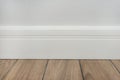 Light matte wall, white baseboard and tiles immitating hardwood flooring Royalty Free Stock Photo