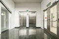 Interior corridor of an office building polished black granite floors and stainless steel double elevator access doors Royalty Free Stock Photo