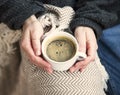 Interior cosy woman hands holding cup of coffee or chocolate with sweater and blanket, comfortable home winter or autumn lifestyle Royalty Free Stock Photo